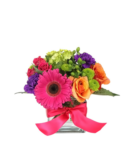 mostly hot pink, purple, orange & green flowers in a glass cube